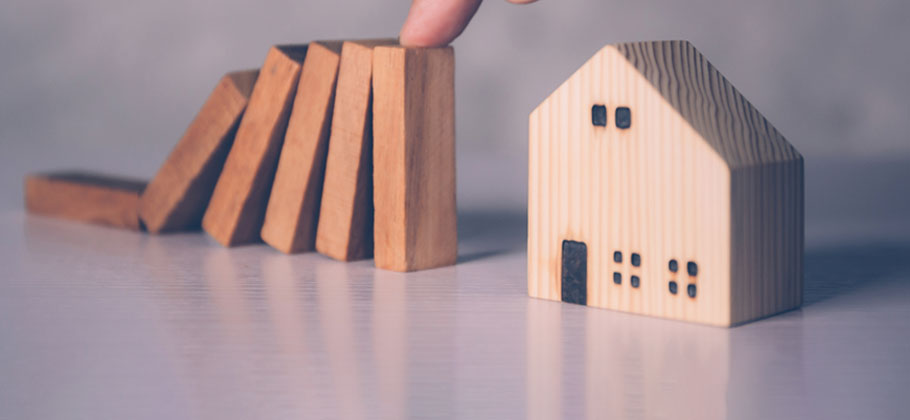 Hands of businessman stop risk about home with block wooden